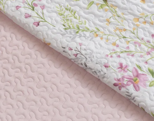 Folded edge on our Meadow Coverlet Set to show its blush pink reverse and floral face pattern together.