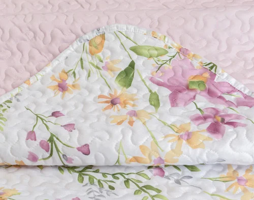 Corner on our Meadow Coverlet Set to show its soft, breathable cotton fabric.