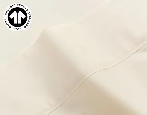 Close-up on the sateen weave and hemmed edge on the flat sheet for our Undyed & Unbleached Organic Cotton Sateen Sheet Set.