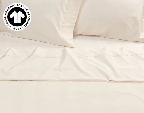 Top view of the flat sheet and pillowcases over a fitted sheet for our Undyed & Unbleached Organic Cotton Sateen Sheet Set.