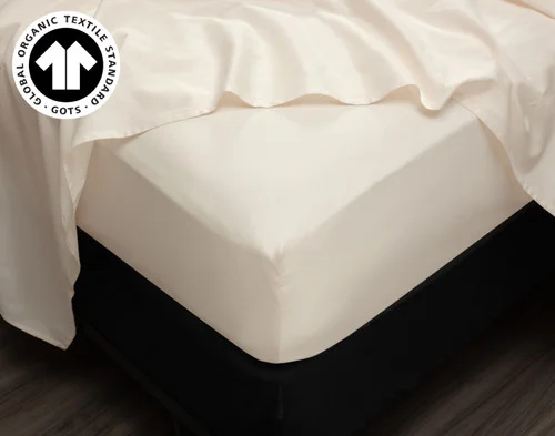 Angled view of our Undyed & Unbleached Organic Cotton Sateen fitted sheet snuggly fitted over a mattress corner.