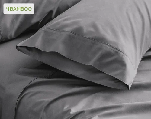 Our Deep Charcoal Bamboo Cotton Pillowcases resting on a bed.