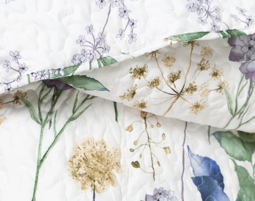 Close up of our Danielle Coverlet Set folded to reveal the main and coordinating floral surfaces.