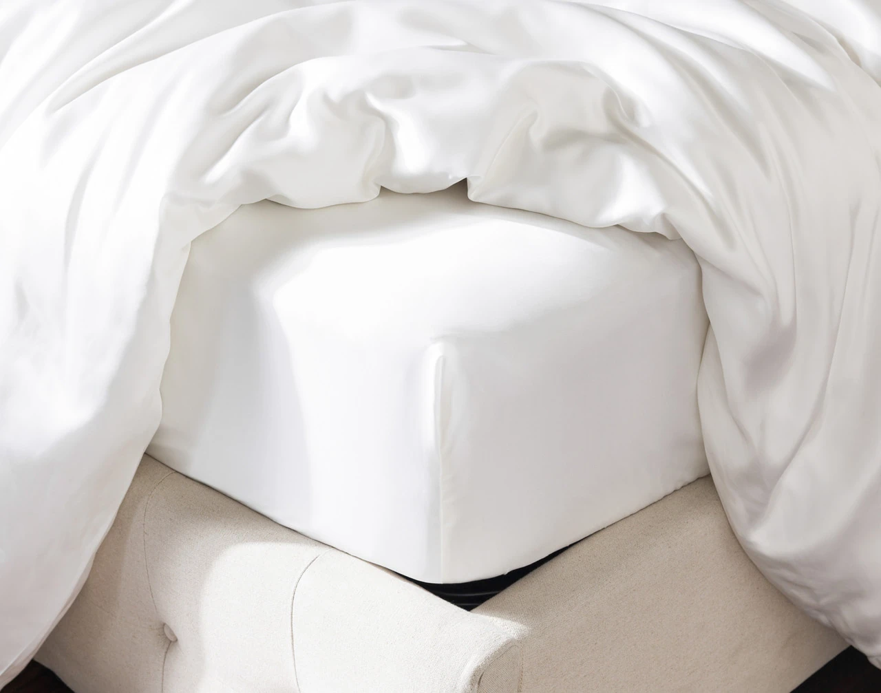 Corner of our Silk Blend Fitted Sheet in Snow over the corner of a mattress.