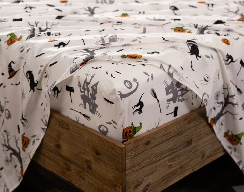 Close-up on the fitted sheet from Haunted House Cotton Percale Sheet Set on the corner of a mattress.