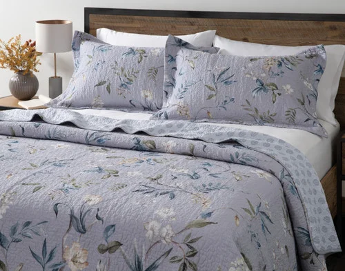 Angled view of our Sara Cotton Quilt Set dressing a queen bed in a minimalist, modern room.