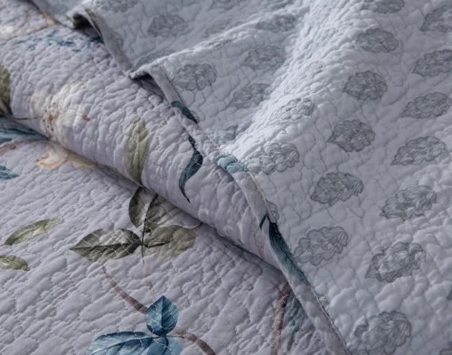 Close up on the folded surface of our Sara Cotton Quilt Set to show the front and reverse designs.