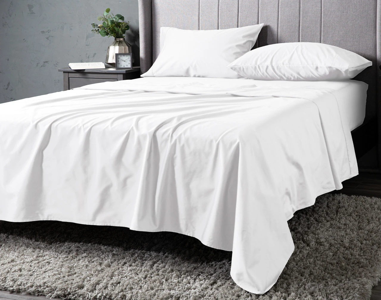 Angled view of our White Dream Sateen Sheet Set dressed over a plain queen bed.