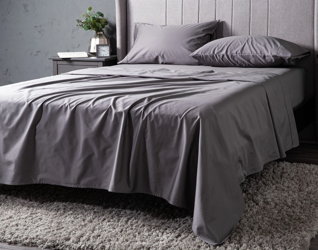 Angled view of our Greywhale Dream Sateen Sheet Set dressed over a plain queen bed.