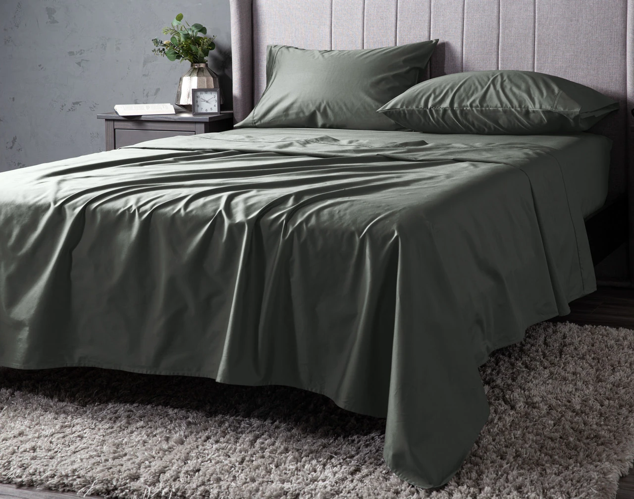 Angled view of our Frosty Green Dream Sateen Sheet Set dressed over a plain queen bed.