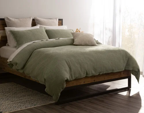 Angled view of our Matosa Duvet Cover dressing a queen bed with matching accessories.