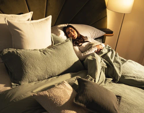 A woman relaxing in bed with our Matosa collection.