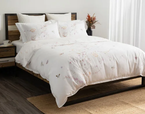 Angled view of our Elysium Duvet Cover dressing a queen bed in a white room.