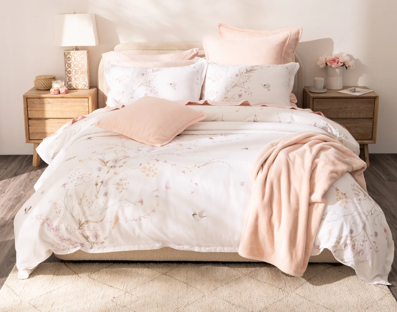 Front view of our Elysium Duvet Cover dressing a queen bed with pink accessories.