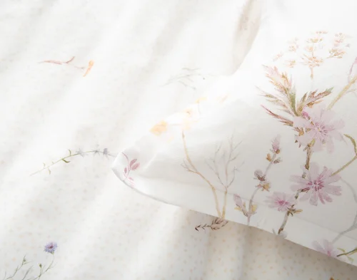 Close up on the corner of our Elysium pillow sham atop our Elysium Duvet Cover.