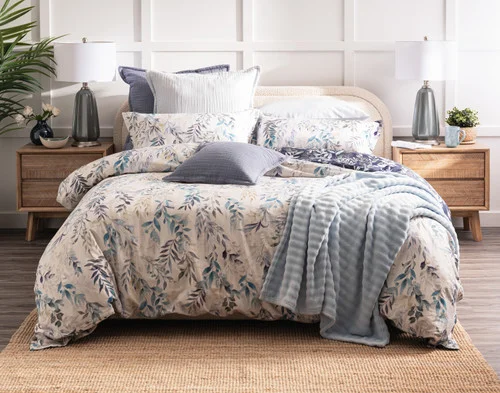 Front view of the light pink side of our Kona Bay Duvet Cover dressed with blue accessories.