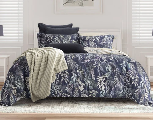 Front view of the navy blue side of our Kona Bay Duvet Cover dressed with green accessories.