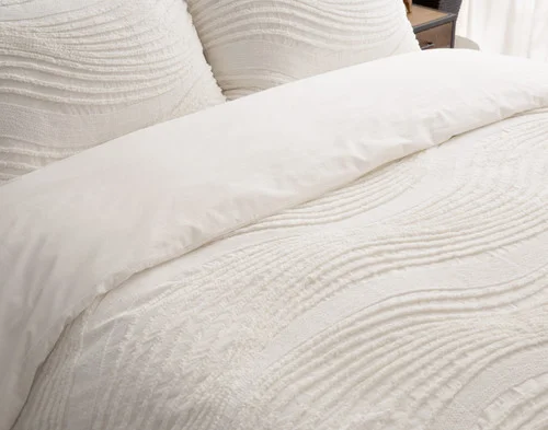 Woman sleeping in a bed dressed in our Savary collection.