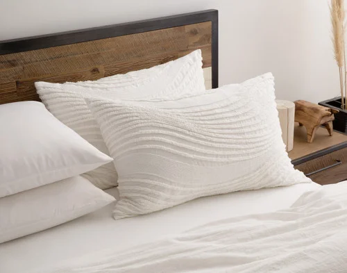 Our Savary Pillow Sham and matching accessories dressing the head of a simple bed.