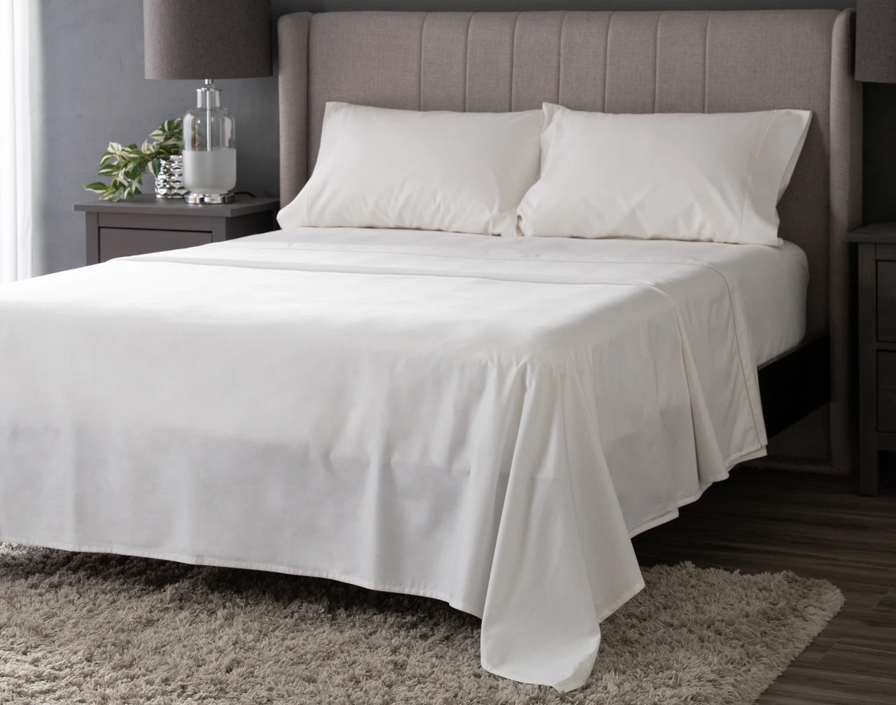Angled view of our White Lace Luxor Egyptian Cotton Sheet Set dressed over a plain queen bed.