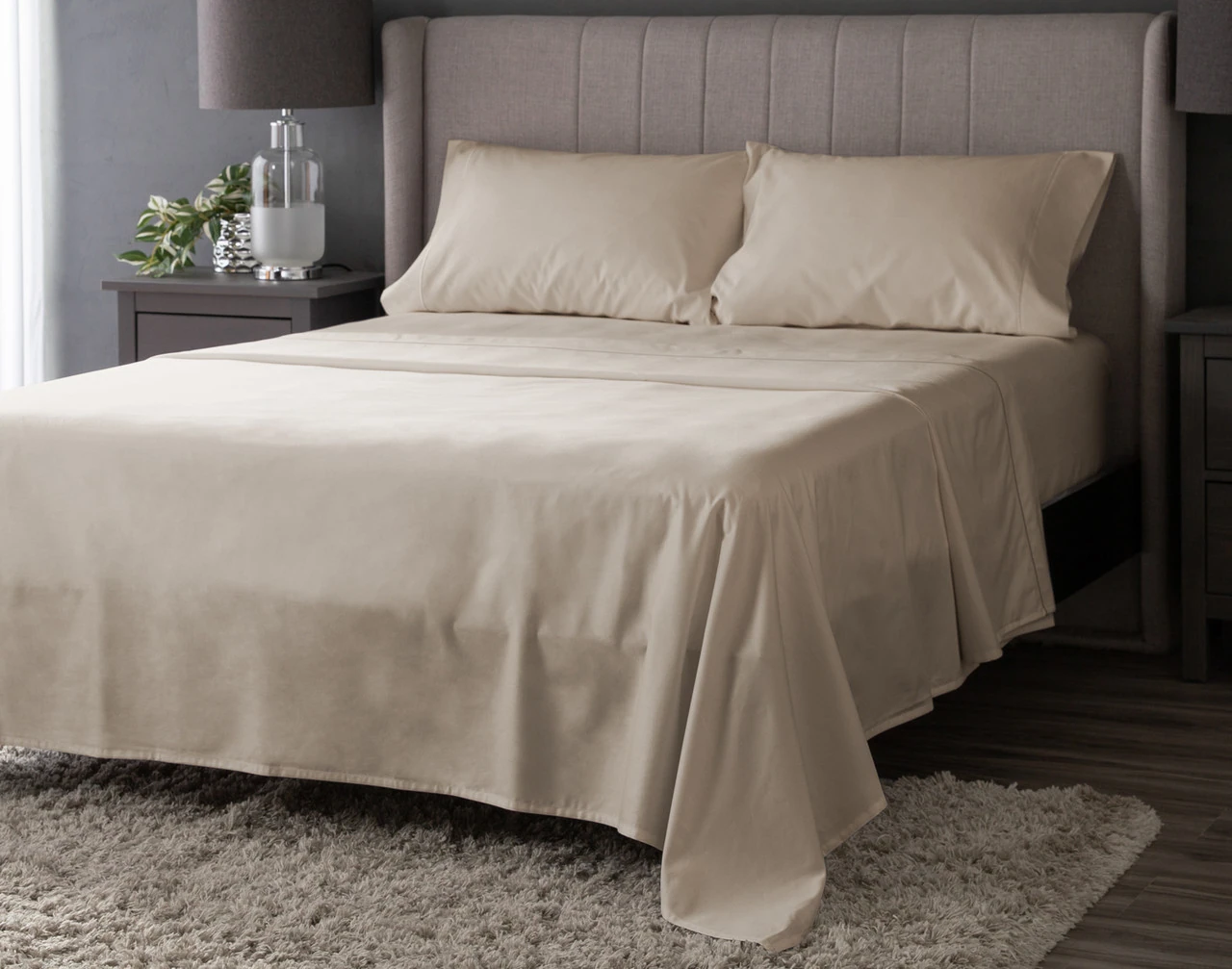 Angled view of our Pumice Luxor Egyptian Cotton Sheet Set dressed over a plain queen bed.