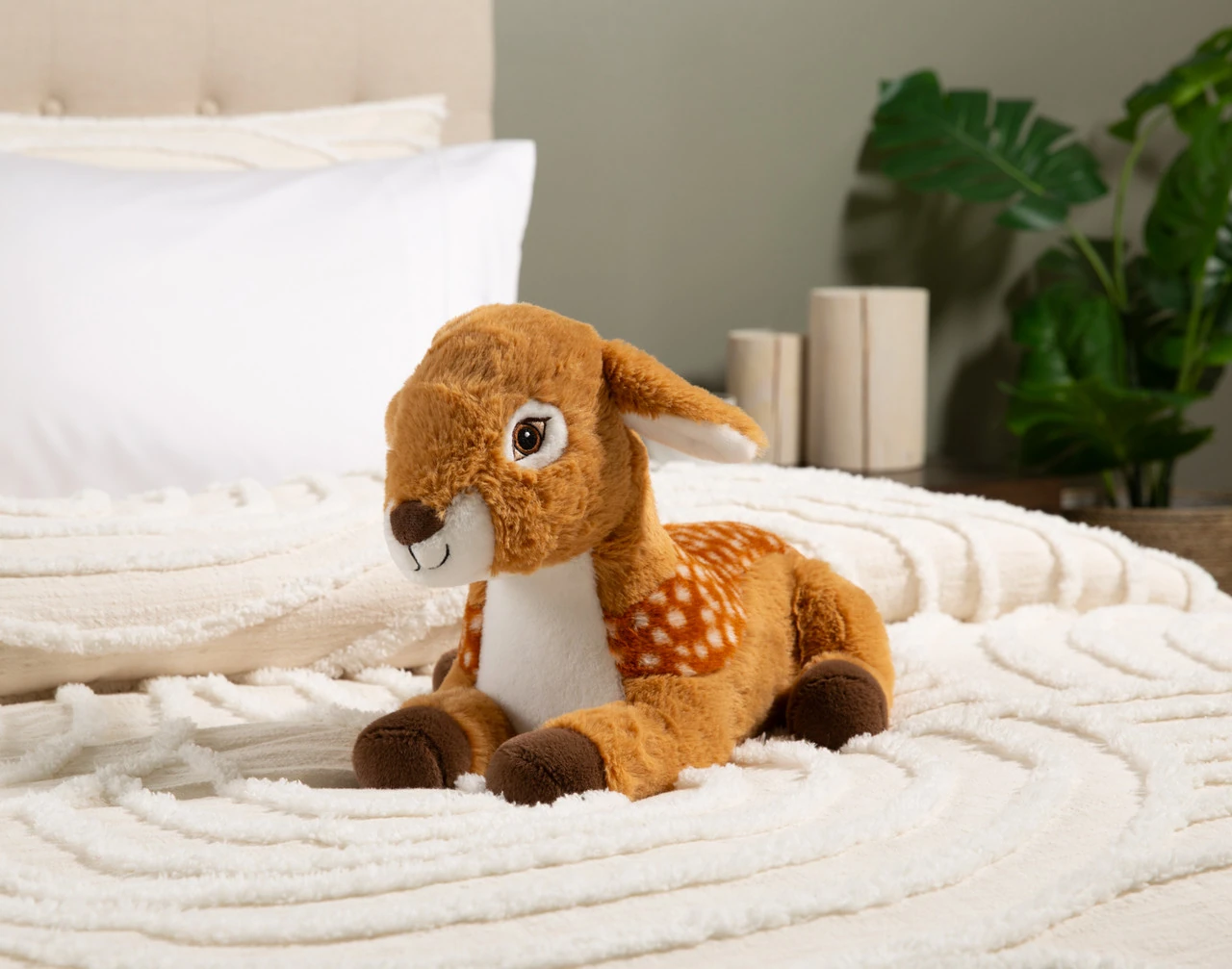 Front view of our Fawn Weighted Cushion sitting on a white bed.