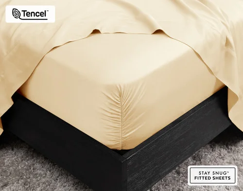 Close-up on the corner of our BeechBliss TENCEL™ Modal Fitted Sheet in Cornsilk fit over a queen mattress.