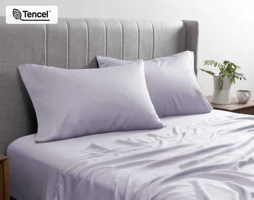 Angled view of the pillowcases from our BeechBliss TENCEL™ Modal Sheet Set in Lavender resting against a headboard.