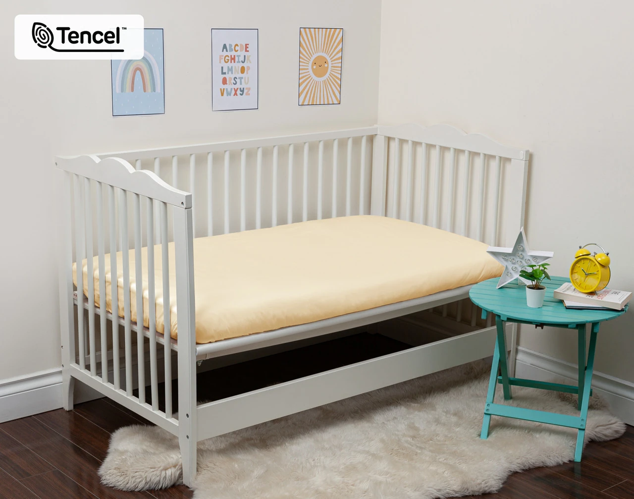 Angled view of our Cornsilk BeechBliss TENCEL™ Modal Crib-Sized Fitted Sheet dressed over a small white crib mattress.