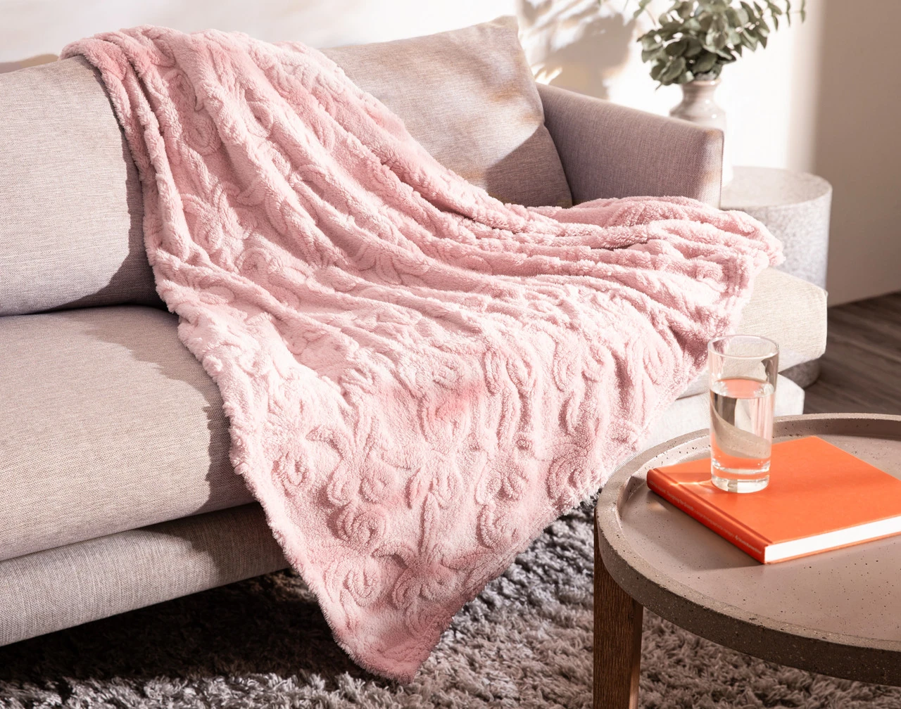Our Valentine's Fleece Throw - Etched Bows draped over a grey couch.