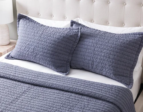 Angled view of the pillow shams from our Anchorage Quilt Set resting against a headboard.