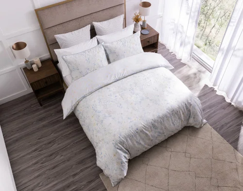 Angled, top-down view of our Josephine Duvet Cover dressing a queen bed in a modern white room.