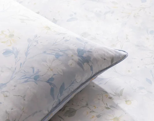 The corner of our Josephine Pillow Sham atop our Josephine Duvet Cover.