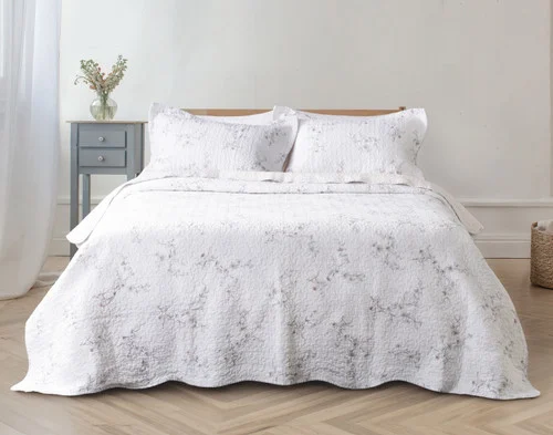 Front view of our Blossom Cotton Quilt Set dressed over an empty queen bed.