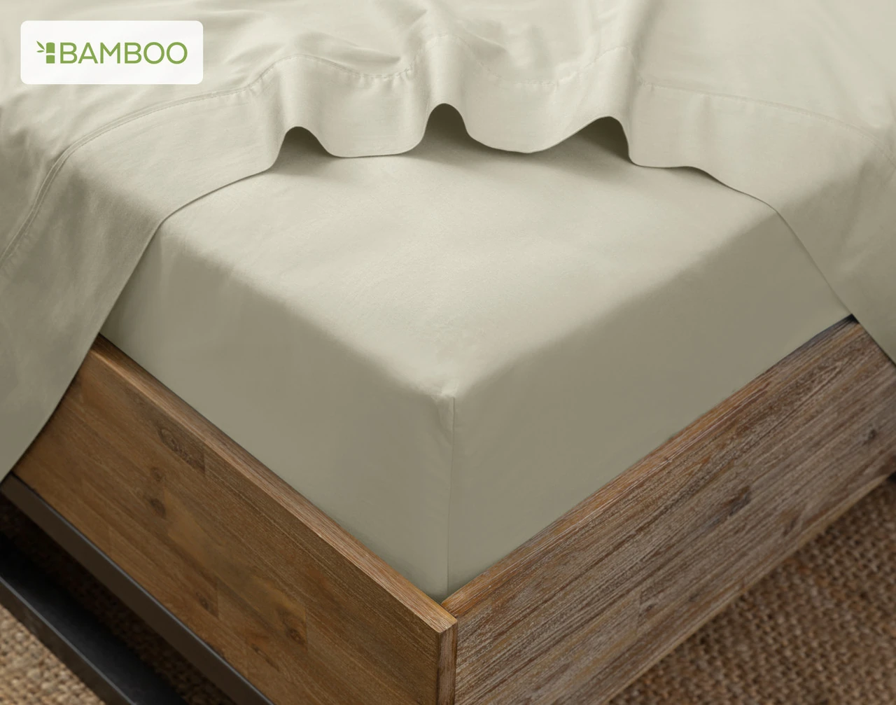 Our Bamboo Cotton Fitted Sheet in Thyme on the corner of a bed with our Bamboo Cotton Flat Sheet in Thyme.