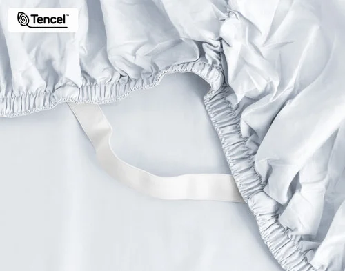 Close-up on the elastic snug fit band on the corner of our Eucalyptus Luxe TENCEL™ Lyocell Fitted Sheet in Blue Chalk.