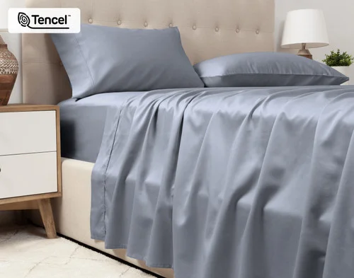 Lower view of our Eucalyptus Luxe TENCEL™ Lyocell Sheet Set in Cliffside to show its flat sheet draped over the side of a queen bed.
