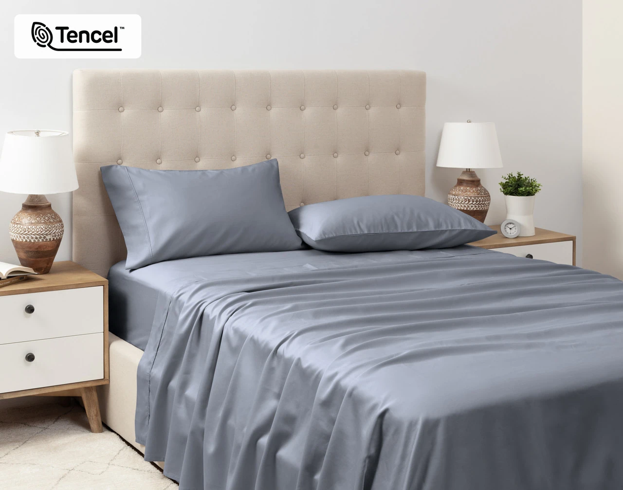 Angled view of our Eucalyptus Luxe TENCEL™ Lyocell Sheet Set in Cliffside dressed over a queen bed in a tidy white bedroom.