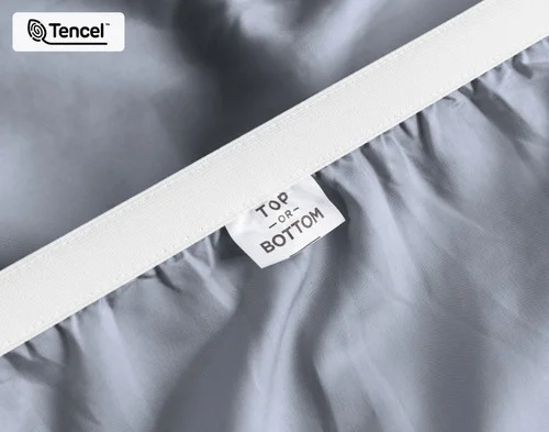 Close-up on the stretched elastic edge and tag stating "Top / Bottom" on our Eucalyptus Luxe TENCEL™ Lyocell Fitted Sheet in Cliffside.