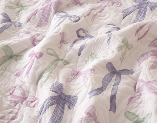 Close-up of the cotton reverse and printed ribbon design on our Bowknots Quilt Set.