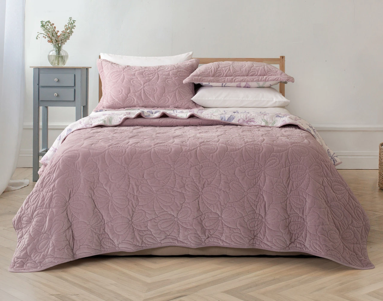 Front view of our Bowknots Quilt Set dressed over a queen bed.