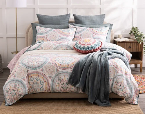 Top-angled view of our Mandira Duvet Cover Set dressing a queen bed with pink accessories.