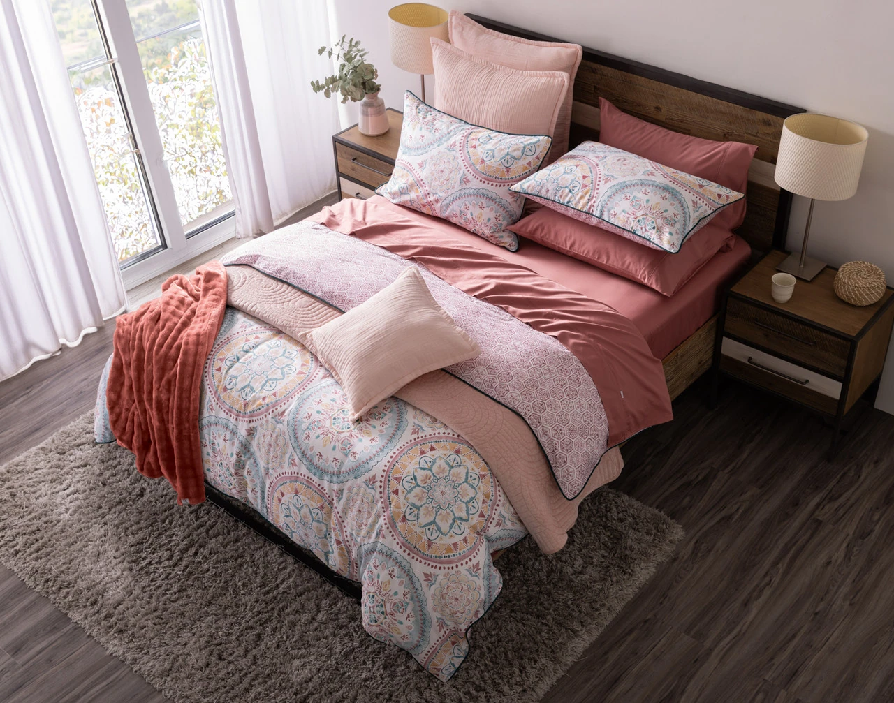 Top-angled view of our Mandira Duvet Cover Set dressing a queen bed with pink accessories.