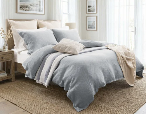Our Cielo Duvet Cover Set dressing a queen bed in a light room with orange accessories.