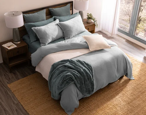 Top-down angled view of our Cielo Duvet Cover Set dressing a bed with green accessories.