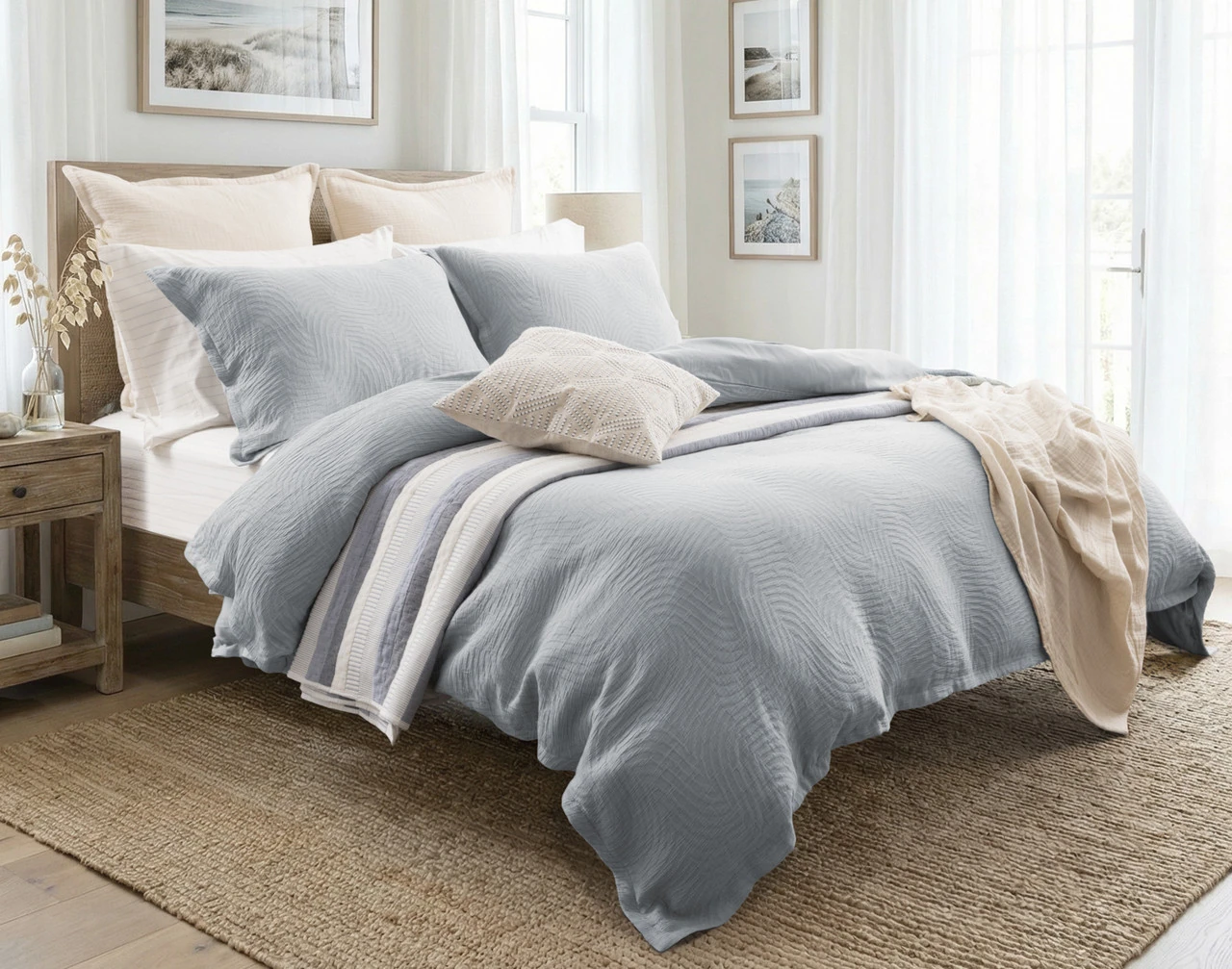 Our Cielo Duvet Cover Set dressing a queen bed in a light room with orange accessories.