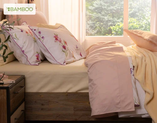 Side view of our Delicata collection dressing a queen bed with yellow and pink accessories.