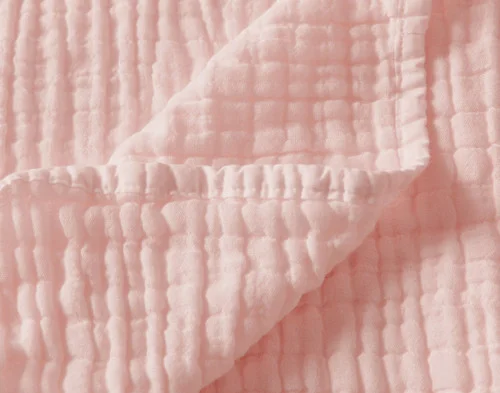 Close up on the folded surface of our Bamboo Gauze Throw in Blossom.