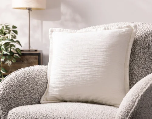 Our Bamboo Gauze Square Cushion Cover in White on a grey chair.