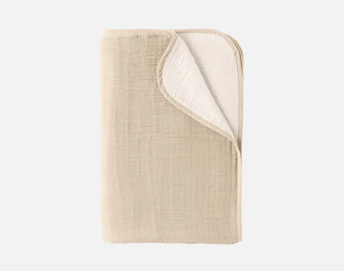 Our Bone Bamboo Gauze Blanket folded into a neat rectangle over a solid white background.